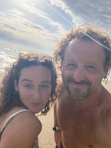 A couple is captured in a close-up selfie on the sandy shores of Strandafgang Zuiderduin, Zandvoort